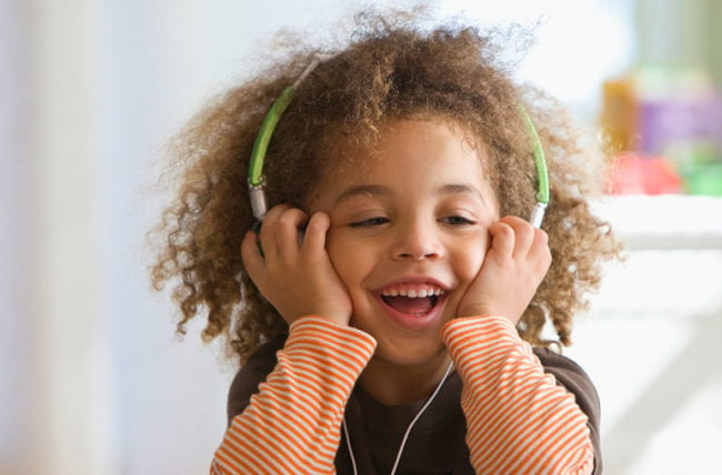 laps kuulab muusikat kõrvaklappe kandes