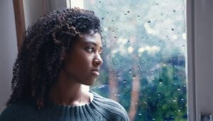 depressed woman looking out window