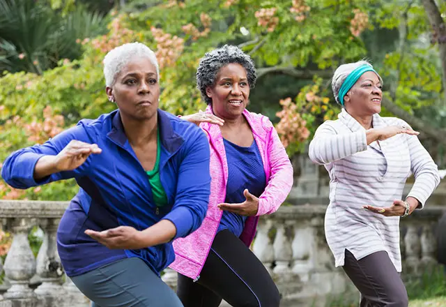 Kolm naist, kes naudivad Tai Chi klassi.