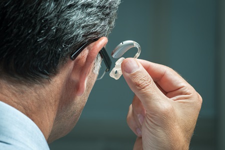 man putting in hearing aid gettyimages 504055937